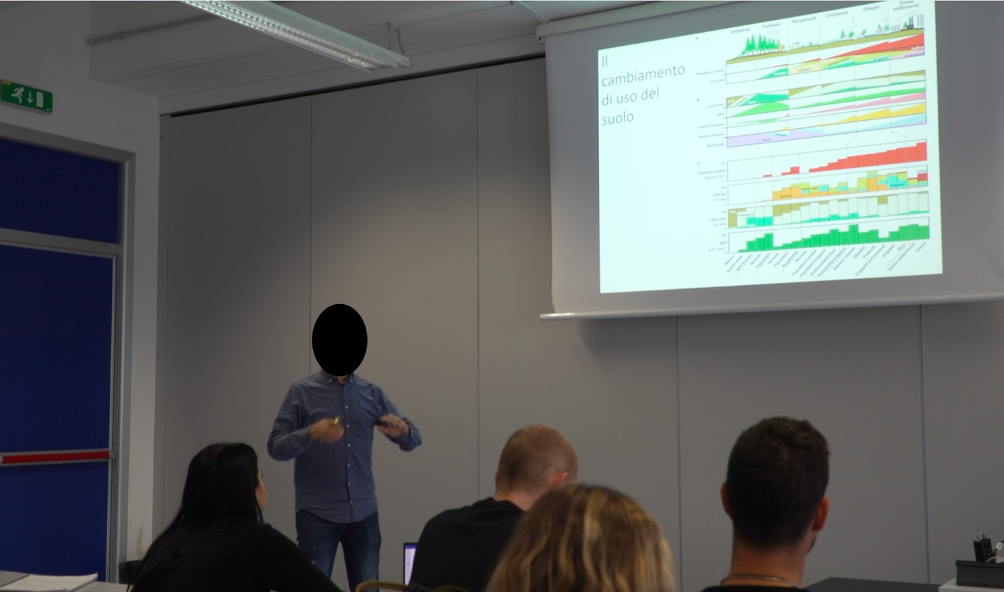 A person standing in front of a screen

AI-generated content may be incorrect.